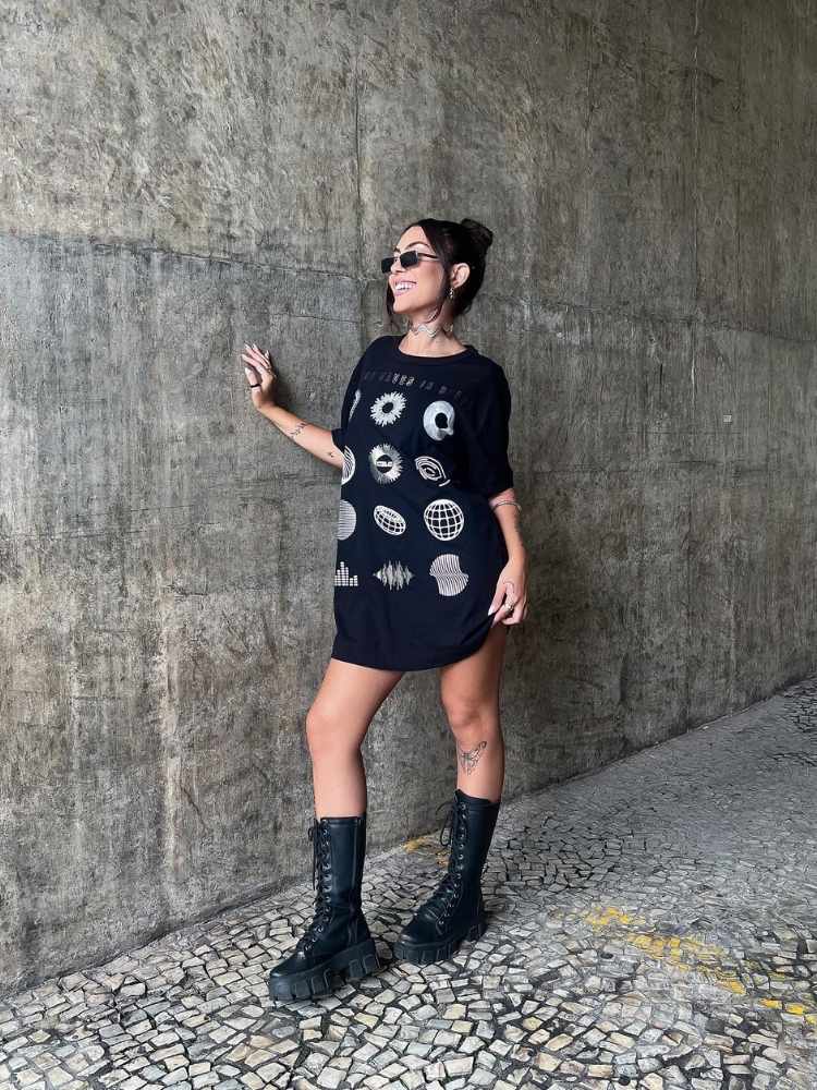 Vitória Lage usando blusão preto estampado e coturno de cano alto 
