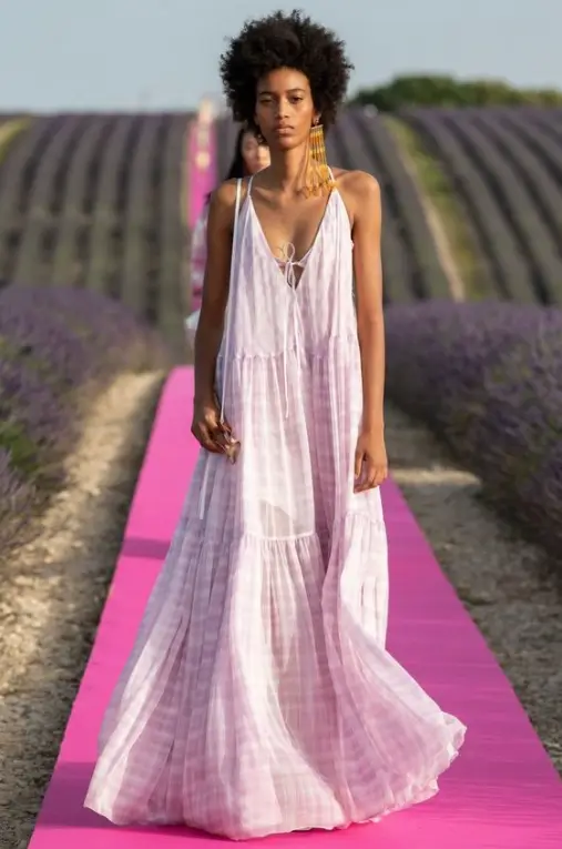 modelo desfilando vestido longo evasê, alça fina com decote v 