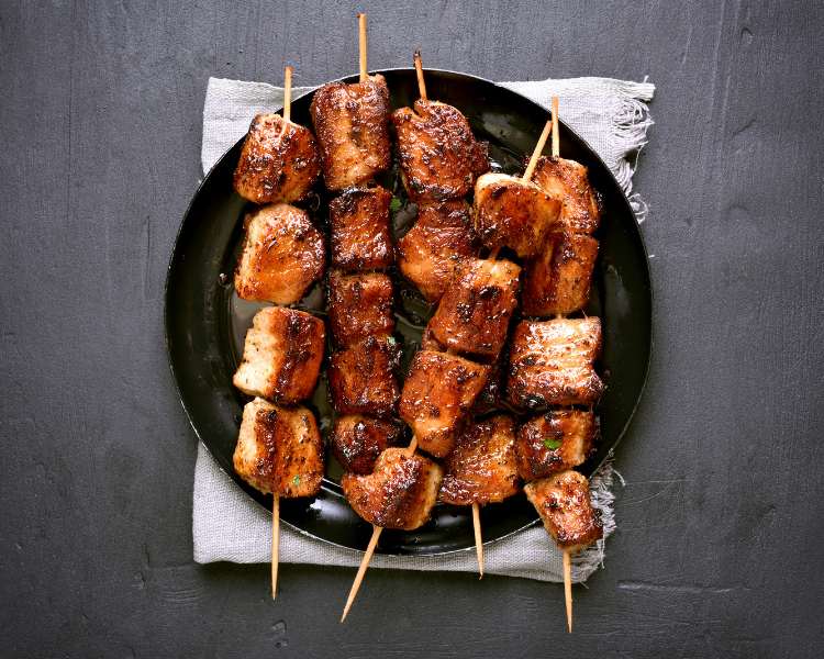 Espetinhos de carno em prato preto - receitas de festa junina