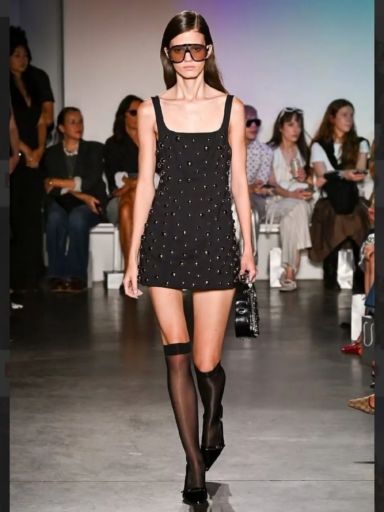 Foto de mulher usando vestido de bolinhas preto Kate Barton