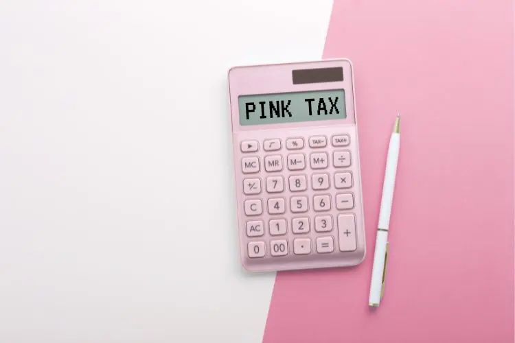 Calculadora rosa escrito Pink Tax ao lado de caneta e com fundo rosa claro e escuro