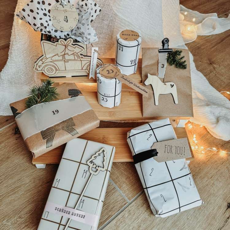 Presentes de Natal minimalistas em embalagens kraft e papel branco, decorados com números, fitas e pequenos enfeites como cavalos de madeira e raminhos de pinheiro. Dispostos sobre uma base de madeira, luzes suaves completam o ambiente acolhedor e festivo.


