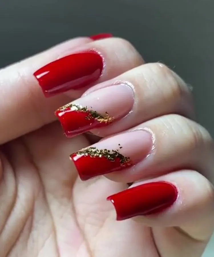 Unhas vermelhas decoradas com folha de ouro
