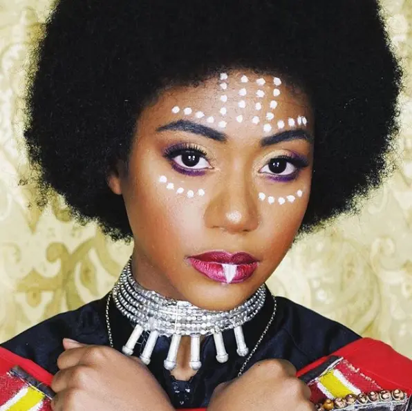 Mulher de pele negra com maquiagem de Wakanda