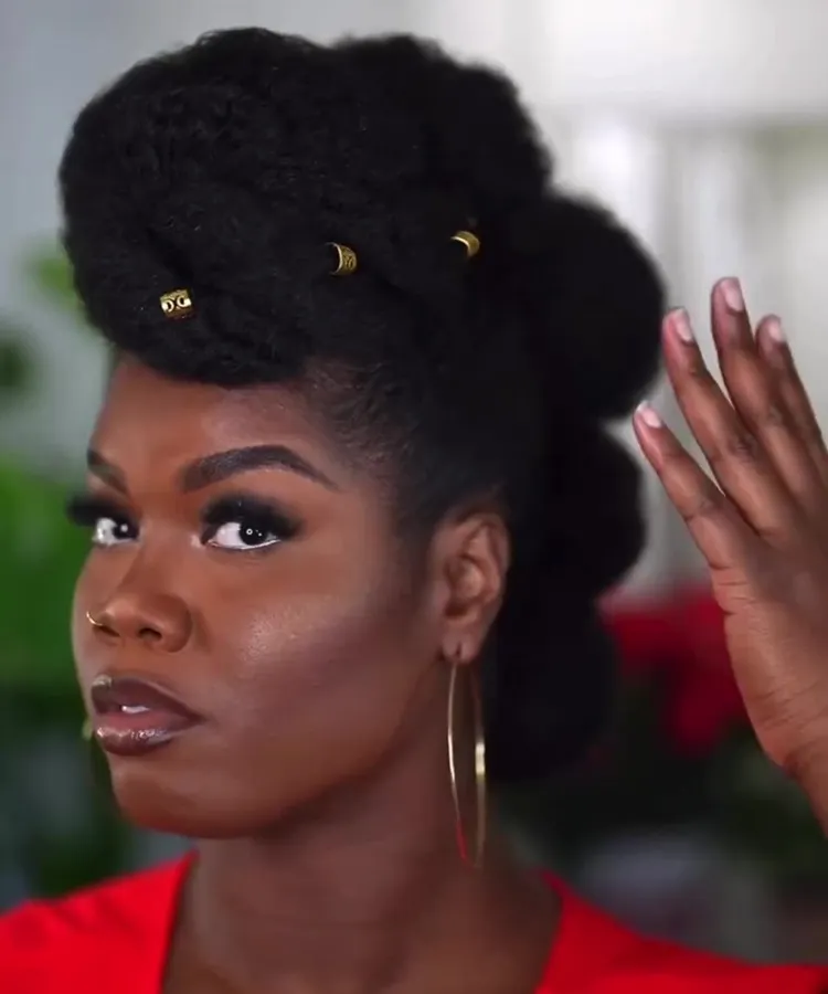 Mulher de cabelo crespo com penteado Coques adornados com acessórios dourados para o Natal