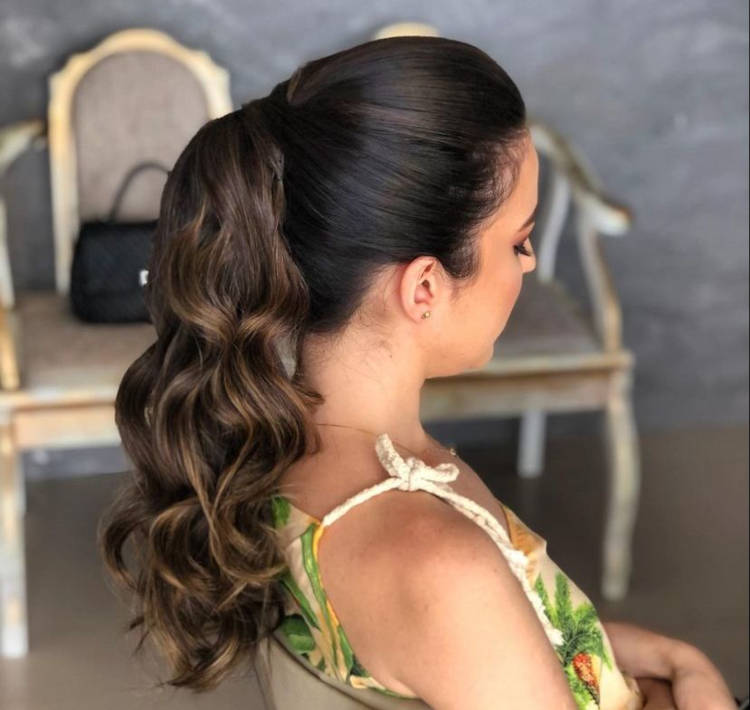 Mulher de pele clara com cabelo castanho em rabo de cavalo com babyliss