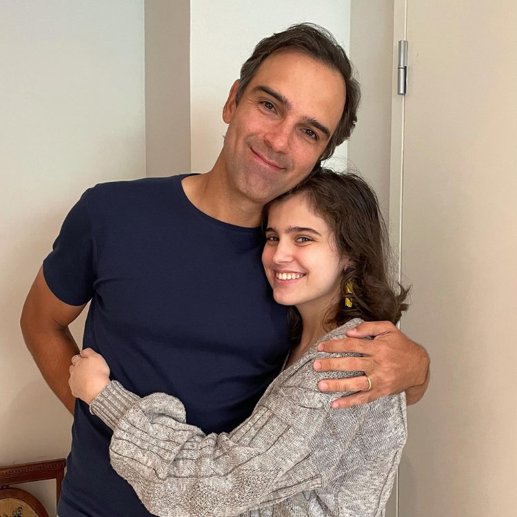 Tadeu de camiseta azul abraçado com Valentina de casaco cinza 