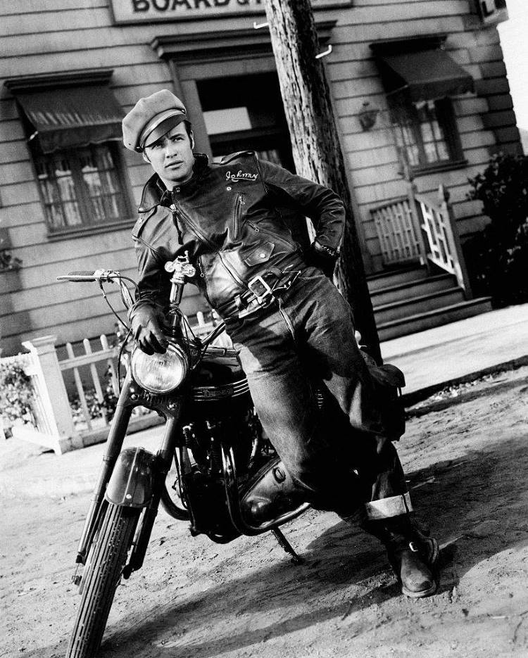 Cena em branco e preto de Marlon Brando de jaqueta biker e calça jeans sobre moto
