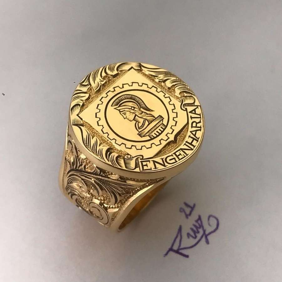 Anel de formatura de engenharia em dourado com símbolo do curso