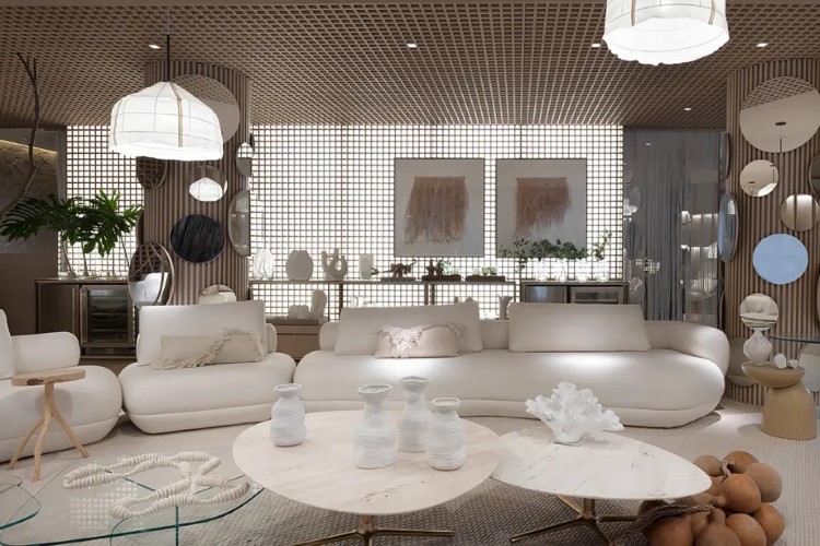 A imagem mostra uma sala de estar moderna e elegante com mobiliário predominantemente branco, incluindo sofás e cadeiras, complementados por uma mesa de centro de madeira e grandes luminárias pendentes. As paredes são adornadas com arte abstrata e a sala é delimitada por uma parede decorativa perfurada que permite a passagem da luz, criando um ambiente acolhedor e tranquilo.


