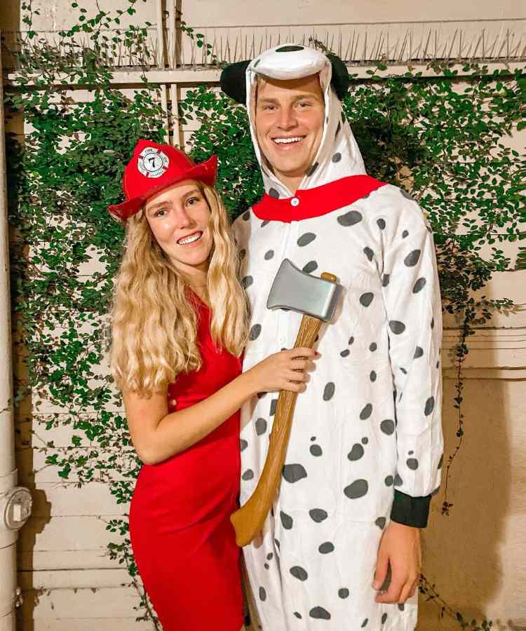 Fantasia de casal para o Halloween: Marshall de Patrulha Canina. Ela usa vestido vermelho, chapéu vermelho e machado, enquanto ele se veste de dálmata 