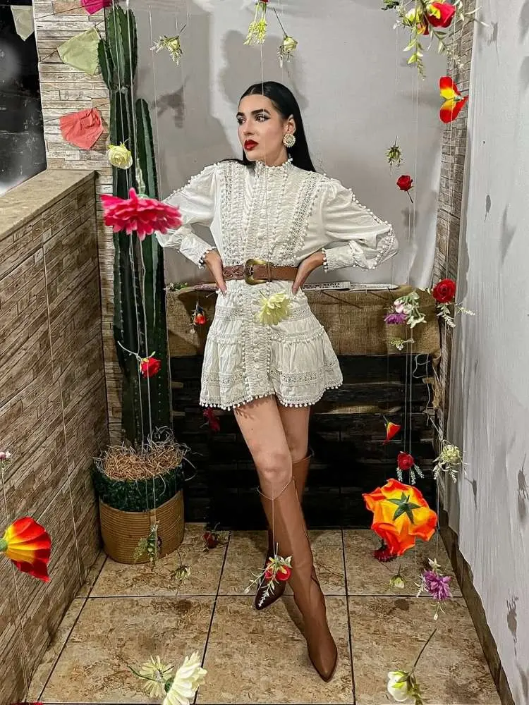 Mulher de pele clara no arraiá usando vestido branco boho, cinto e bota western 