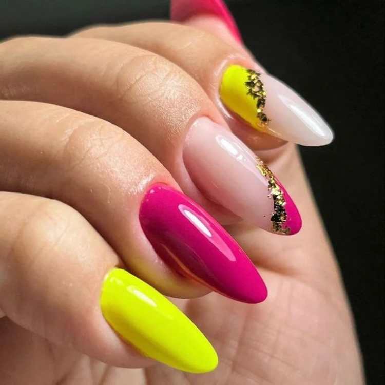 Unhas verde neon e rosa com decoração dourada.