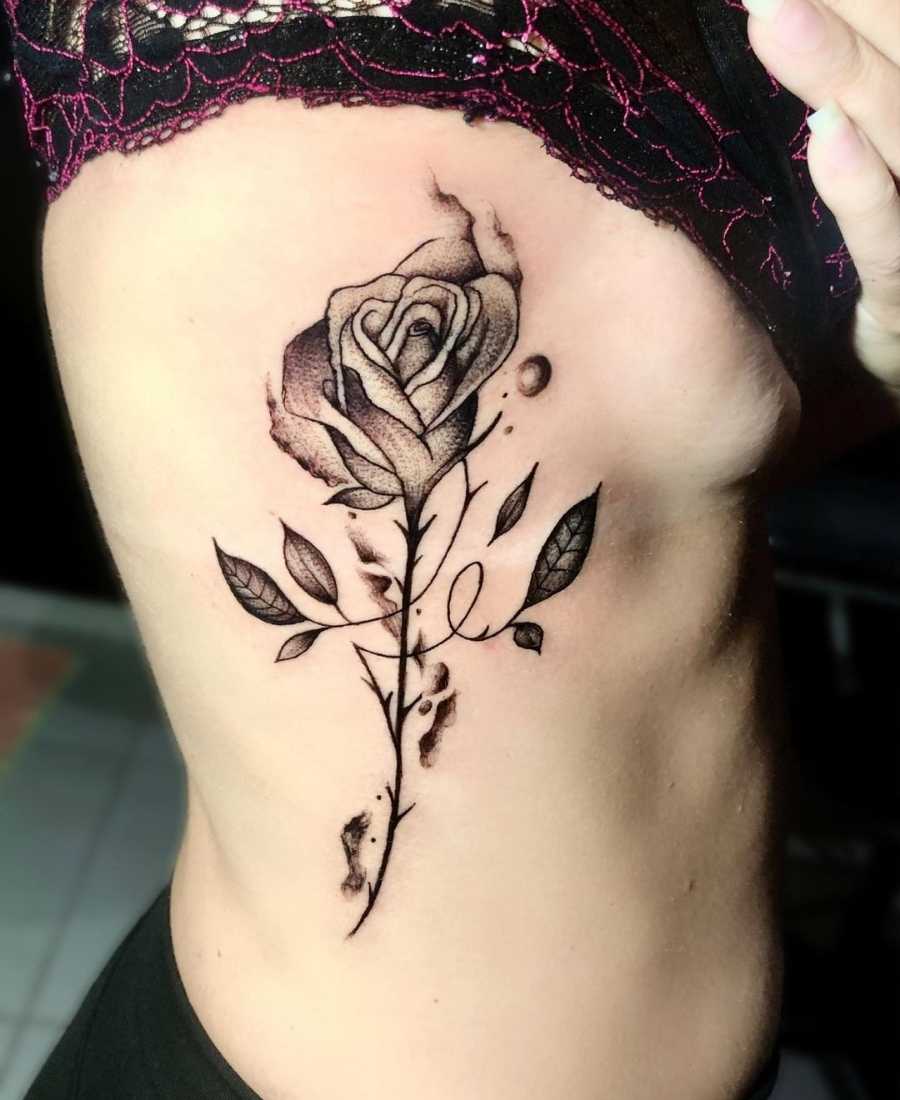 Foto de tattoo com a palavra fé em forma de rosa.