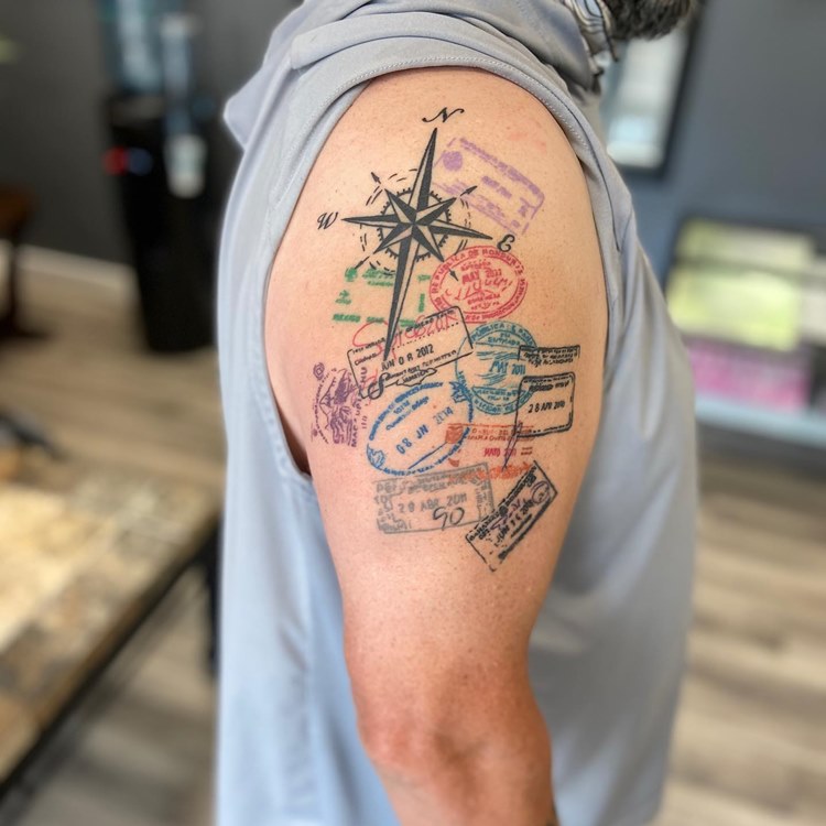 tatuagem de viagem masculina de bússola e carimbos de países diferentes de passaportes