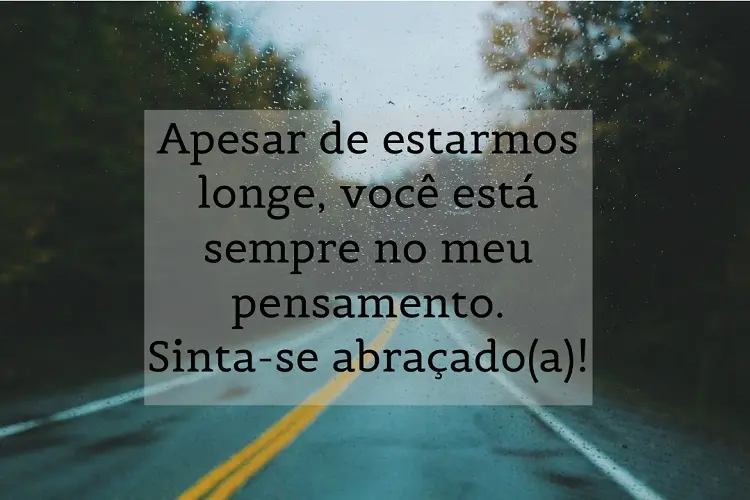 Foto de para-brisa em estrada na chuva e frase: Apesar de estarmos longe, você está sempre no meu pensamento. Sinta-se abraçado(a)!