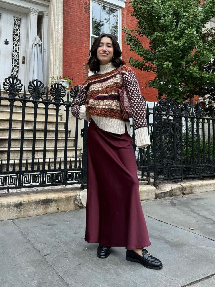 mulher usando suéter estampado, saia de cetim marrom e sapato preto