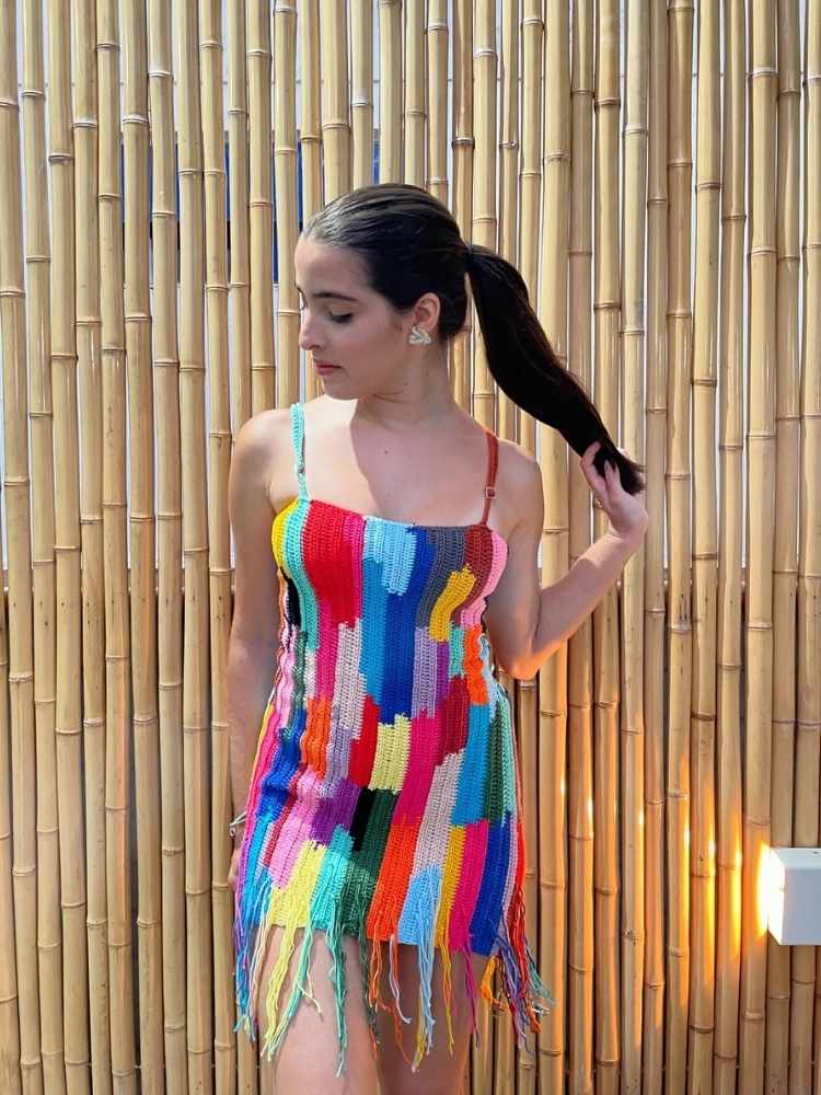 Mulher de pele clara com vestido colorido de crochê