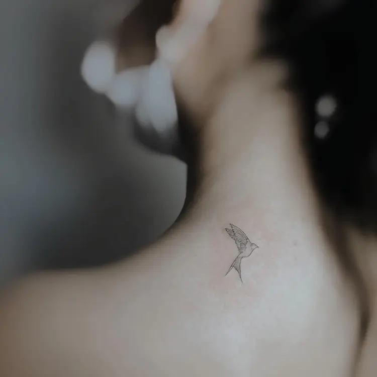 Tatuagem pequena fineline de pássaro voando