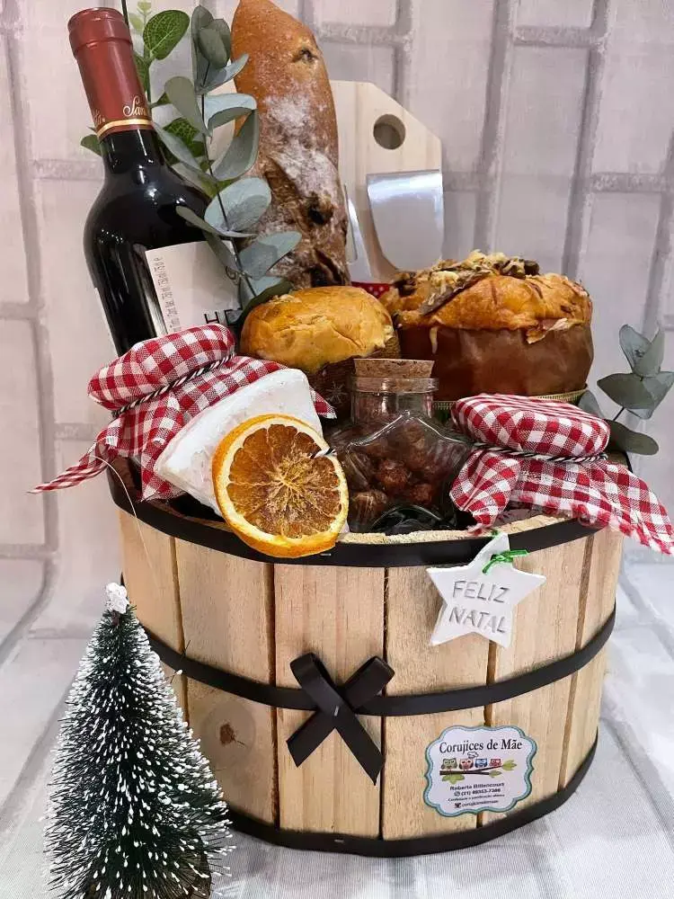 Cesto de madeira com doces, frutas e bebidas. 