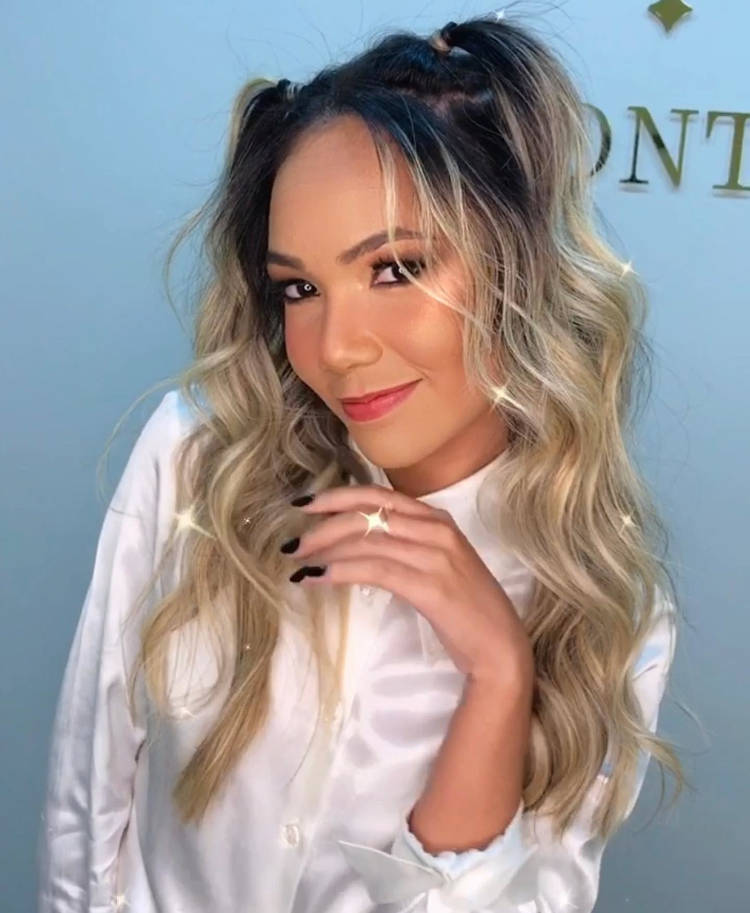 Mulher com cabelo loiro com duas mechas presas no topo.