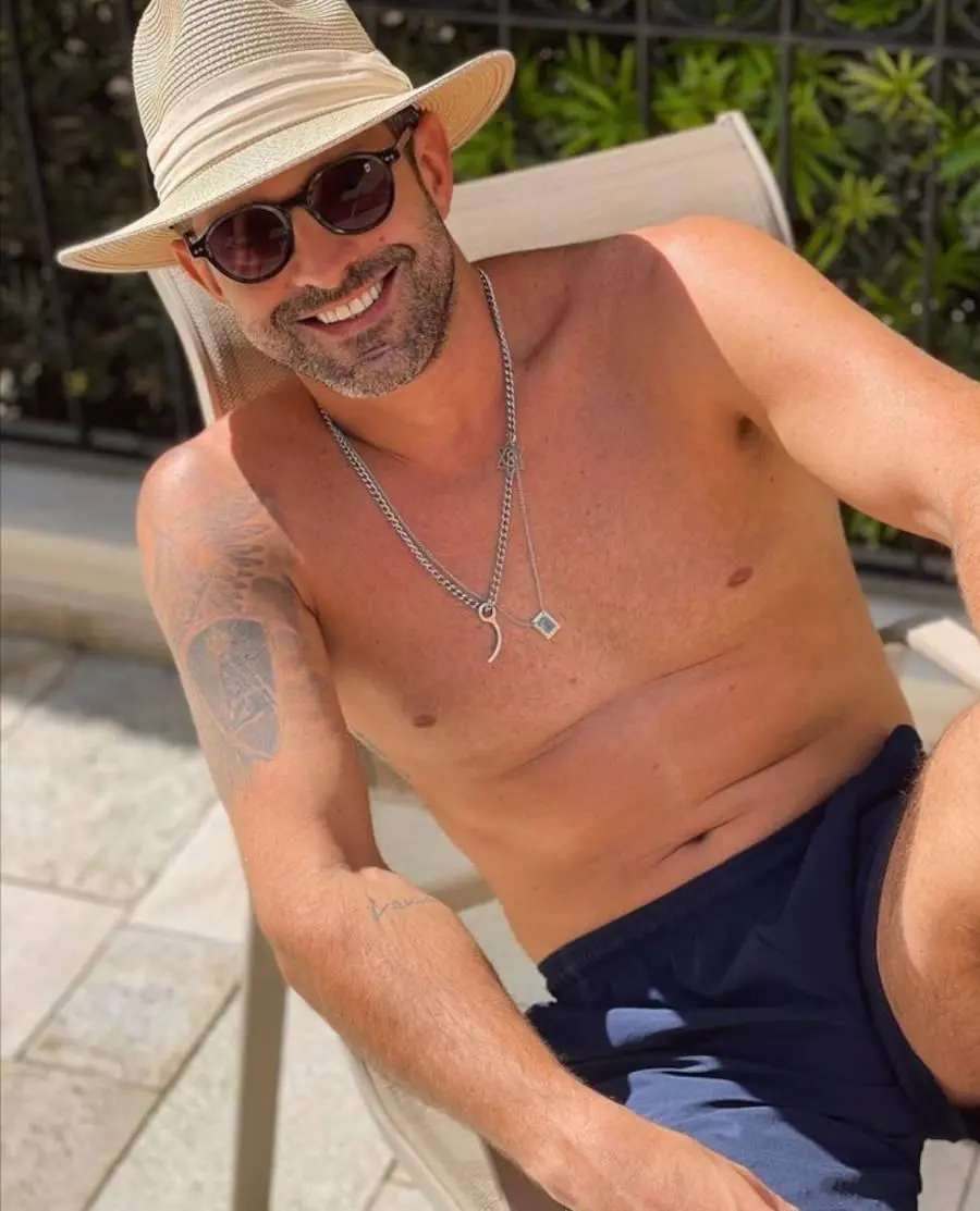 Foto de Iran Malfitano no sol com suas tatuagens no braço