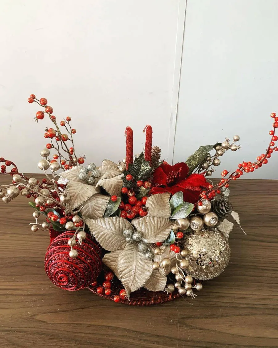 Arranjo pequeno de natal com velas finas.