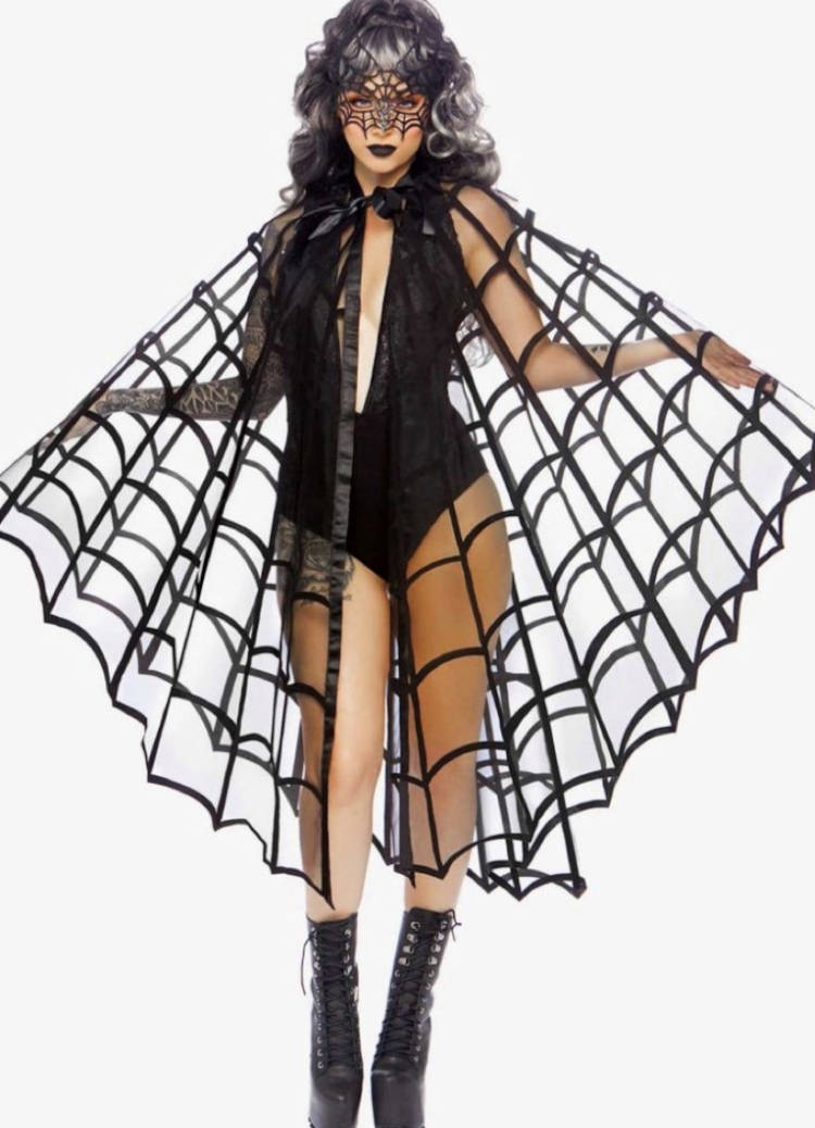 Mulher de pele clara usando máscara de teia, body preto e capa de teia
