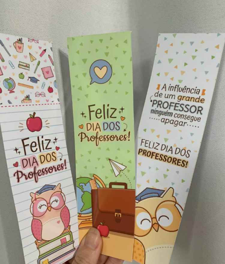 mão segurando 3 marca páginas de dia dos professores