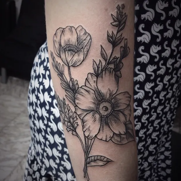 tatuagem preta de flor no braço
