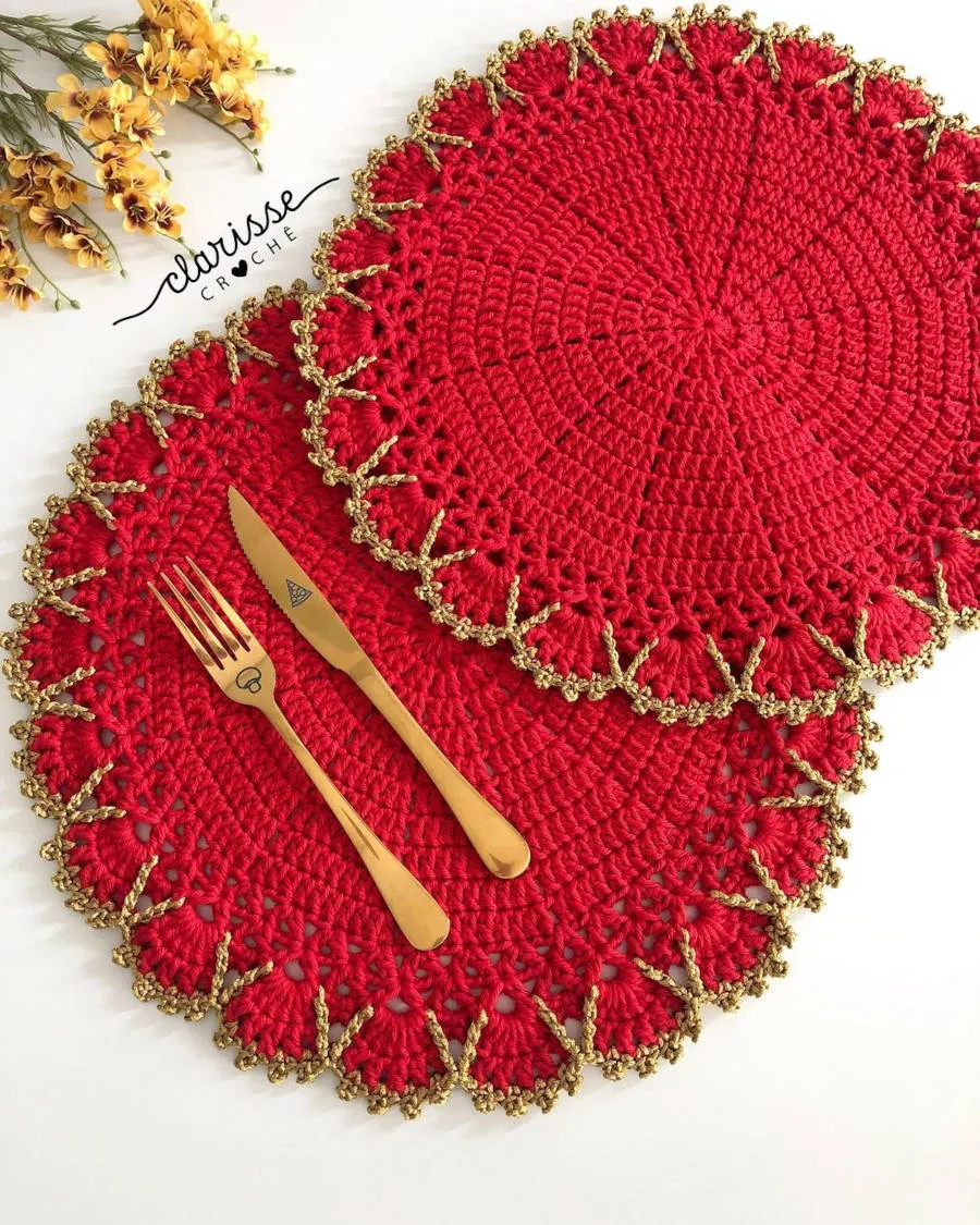 Sousplat vermelho e dourado com talheres dourados.