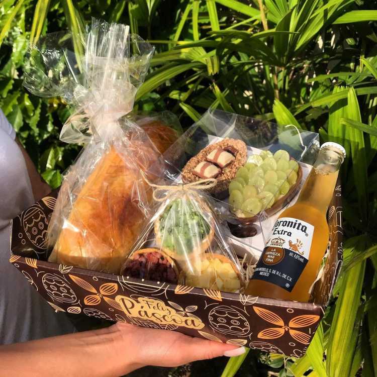 Cesta de Páscoa de produtos regionais, com cerveja, ovos de páscoa caseiros e pão.
