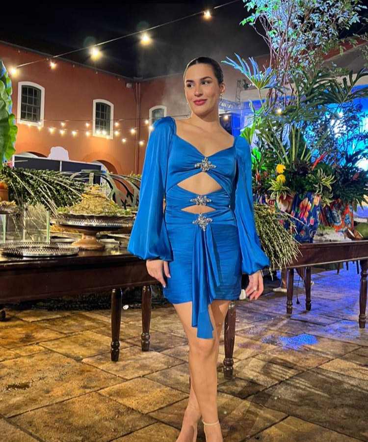 Lívia Aragão, filha de Didi, usando vestido azul com decote + mangas bufantes