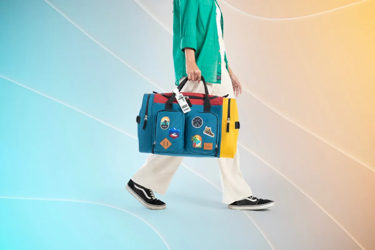 Pessoa caminhando segurando bolsa colorida inspirada na lojinha do Big Brother Brasil