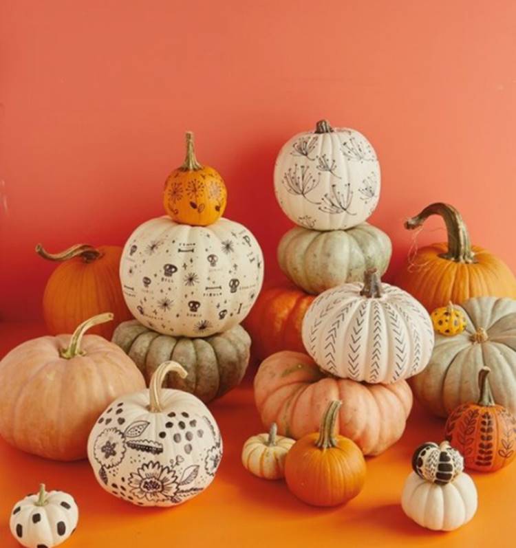 Foto de abóboras decoradas com pincéis para o Halloween.
