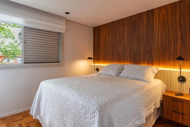 Quarto de casal com madeira escura e roupa de cama branca