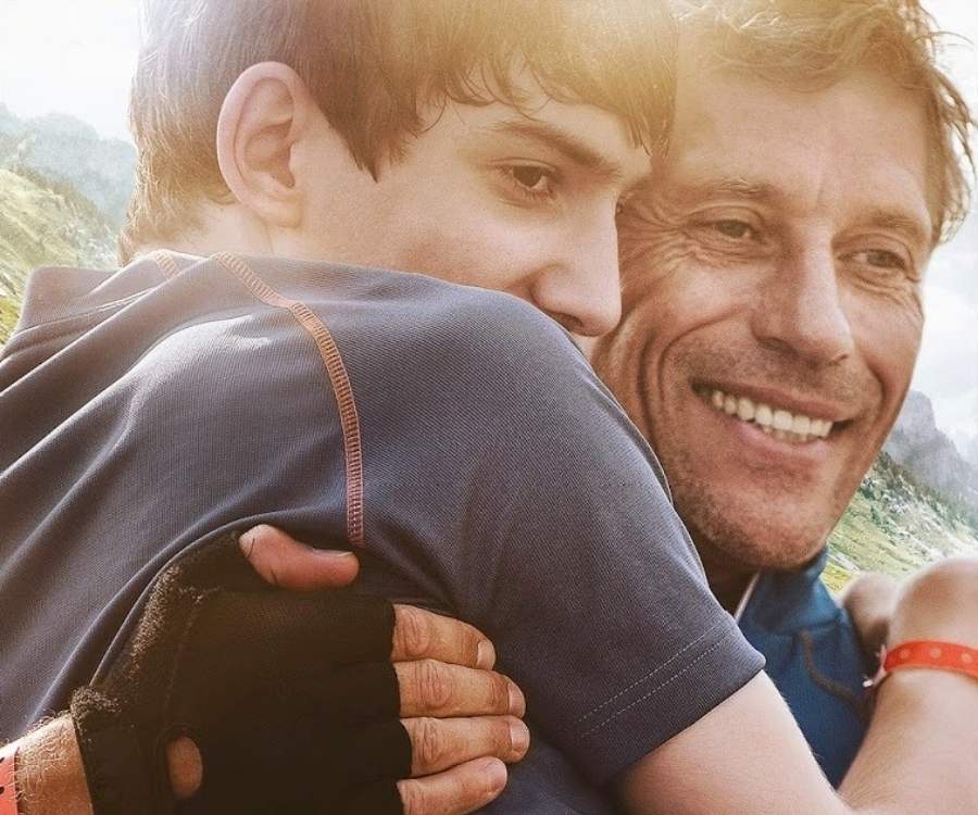 Rosto dos atores do filme "Meu Pai, Meu Herói". Pai está segurando filho especial no colo.