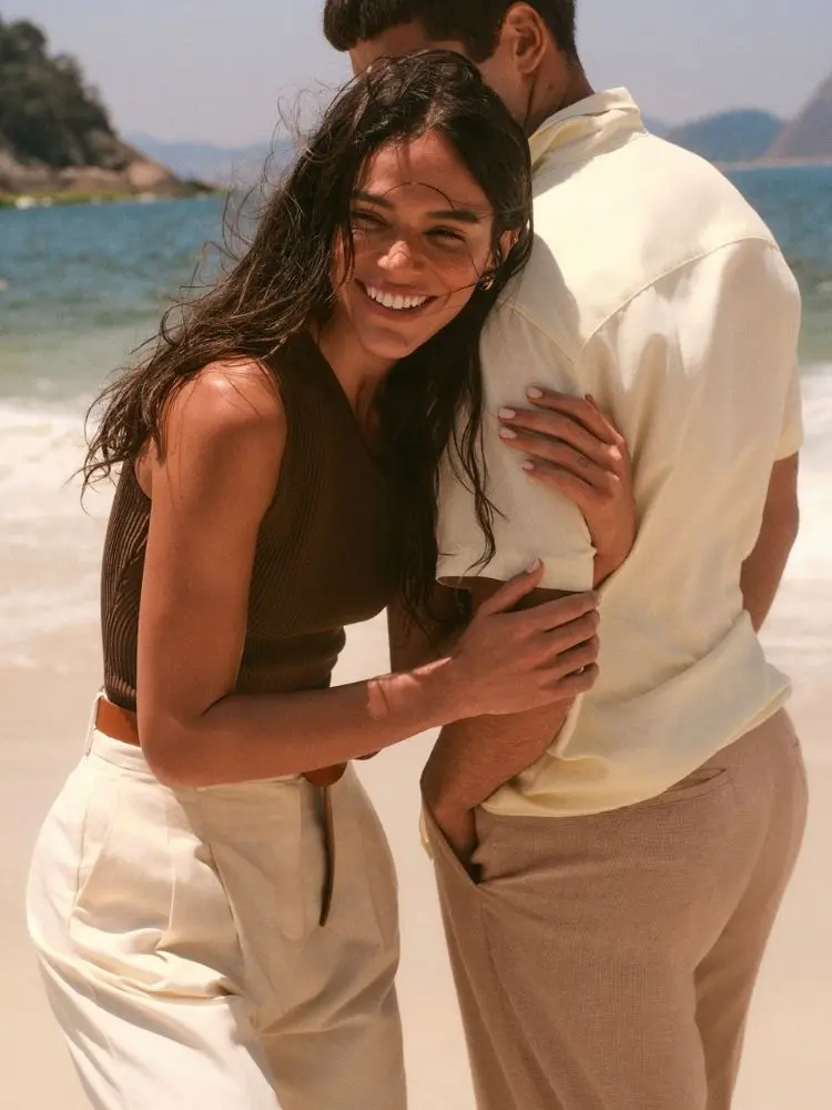 Bruna Marquezine na praia usando regata marrom e calça bege