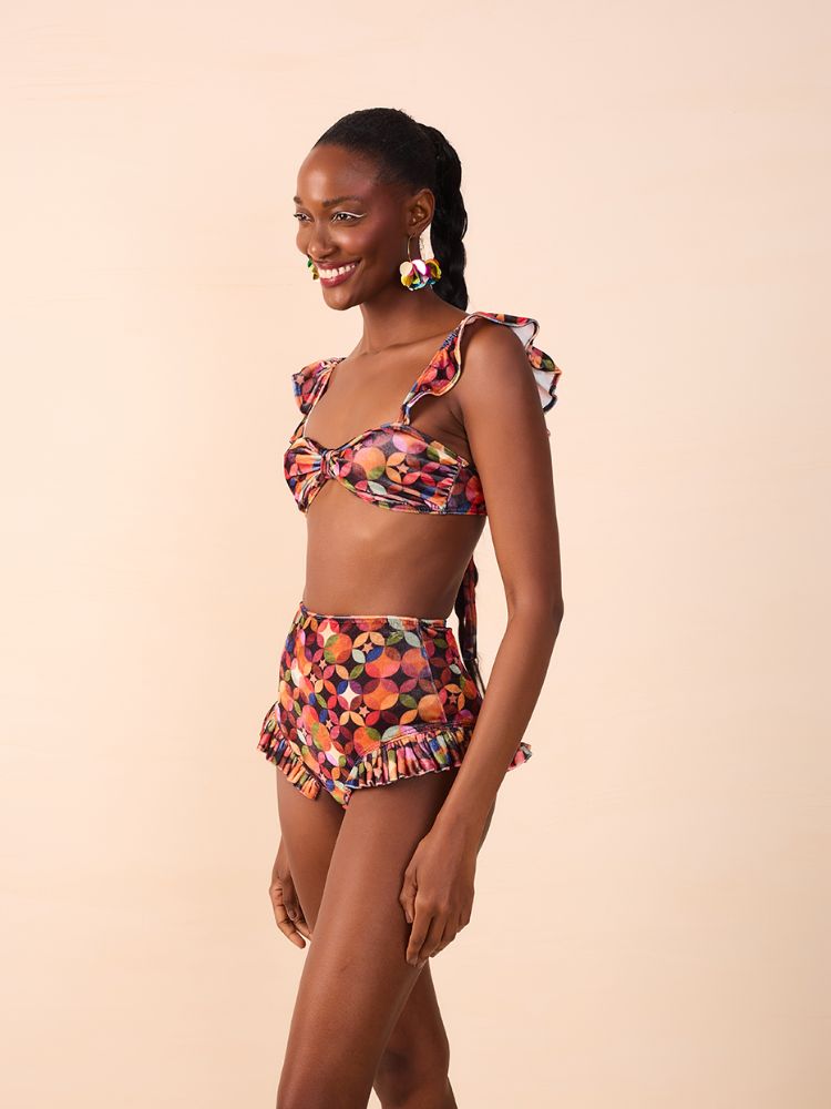 Mulher de pele negra usando top e hot pant coloridos
