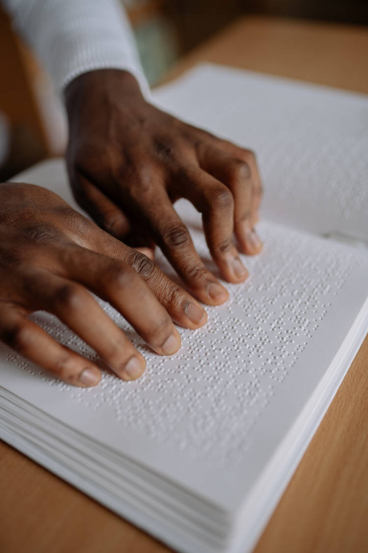 Homem lendo em braille. Homem cego lendo livro em braille.