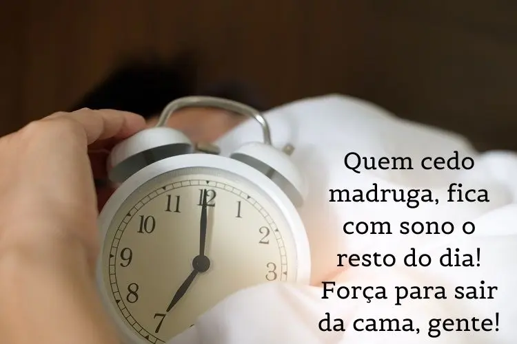 Foto de despertador branco em lençol branco e frase: quem cedo madruga, fica com sono o resto do dia! Força para sair da cama, gente!