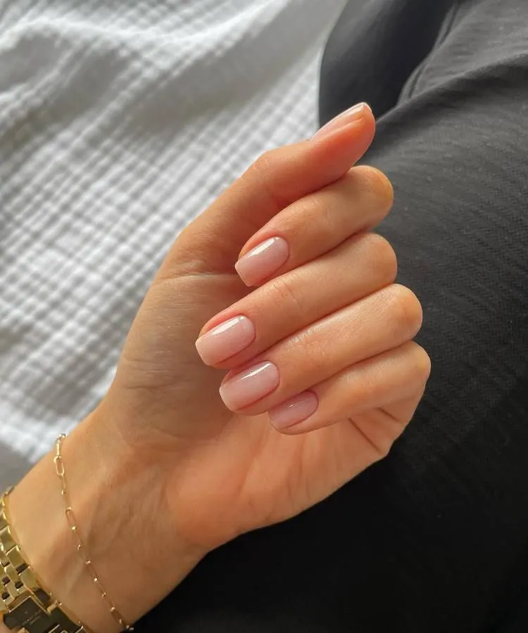 Unhas elegantes no formato quadrado com a ponta arredondada, no tamanho curto, cor clara.
