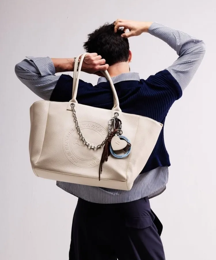 Modelo segurando bolsa off white da coleção de Alexandre Pavão e Pool