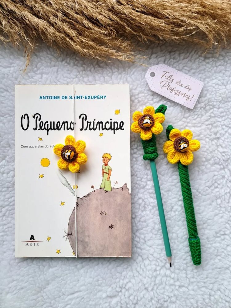 Livro O Pequeno Príncipe com marcador de página, lápis e caneta com flor de crochê