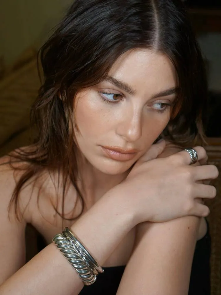 Mulher de pele clara usando no makeup makeup, com apenas corretivo, blush, máscara de cílios e um batom da cor da boca. 
