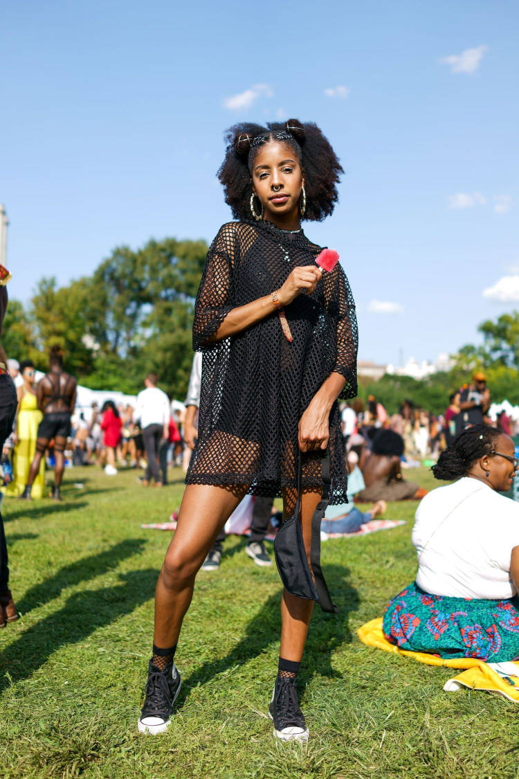 Mulher de pele negra usando roupa preta por baixo de vestido tela preto