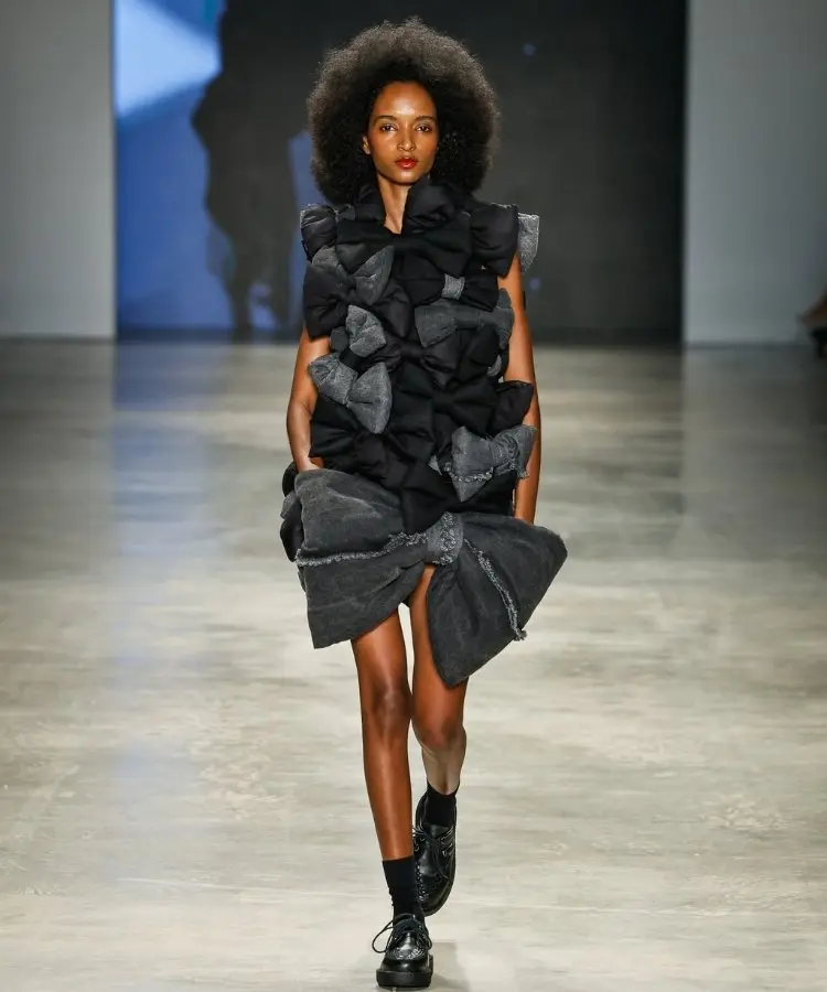 Foto de modelo na passarela usando vestido de laços cinzas