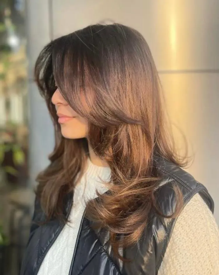 mulher de cabelo médio liso castanho e franja média