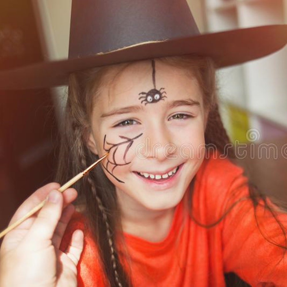 Menina sendo pintada no rosto - Halloween em casa. Pintura de aranha + teia de aranha.