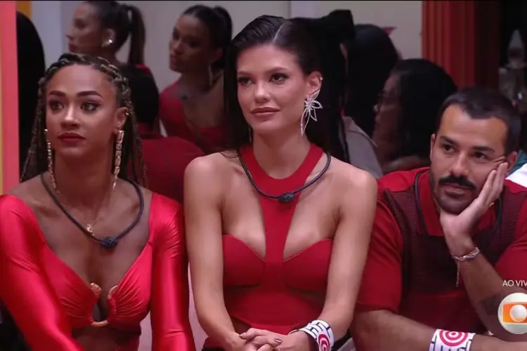 Foto mostra Aline, Vitória Strada e Mateus na sala do BBB com roupas vermelhas